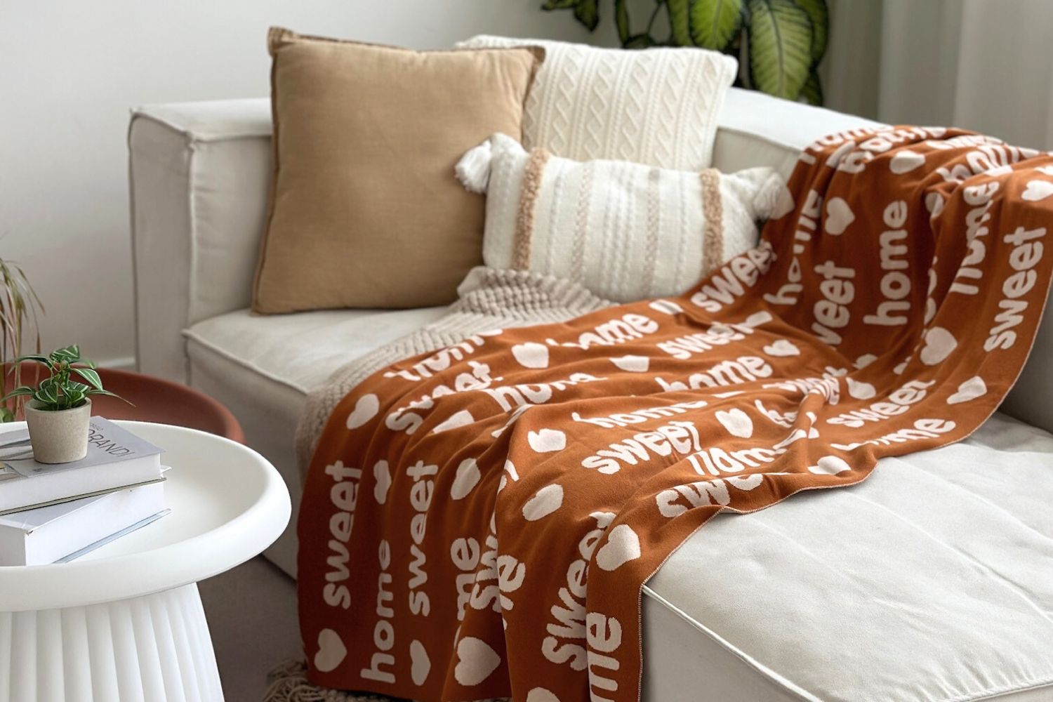 Personalized Knitted Name Blanket in Rust Color, laid flat on the sofa